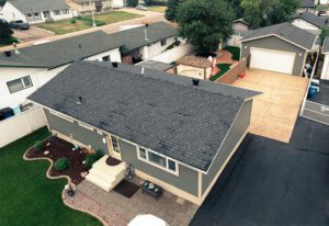 Aerial view of a suburban home with a well-maintained yard and detached garage.