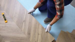 A man is installing wood flooring